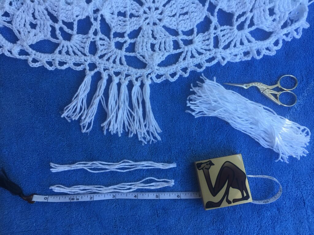 I cut 5 6-inch strands of yarn for each space along the border and attached with a simple slip knot.