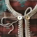 Sew on buttons. Attach tails of crochet loop to right button.