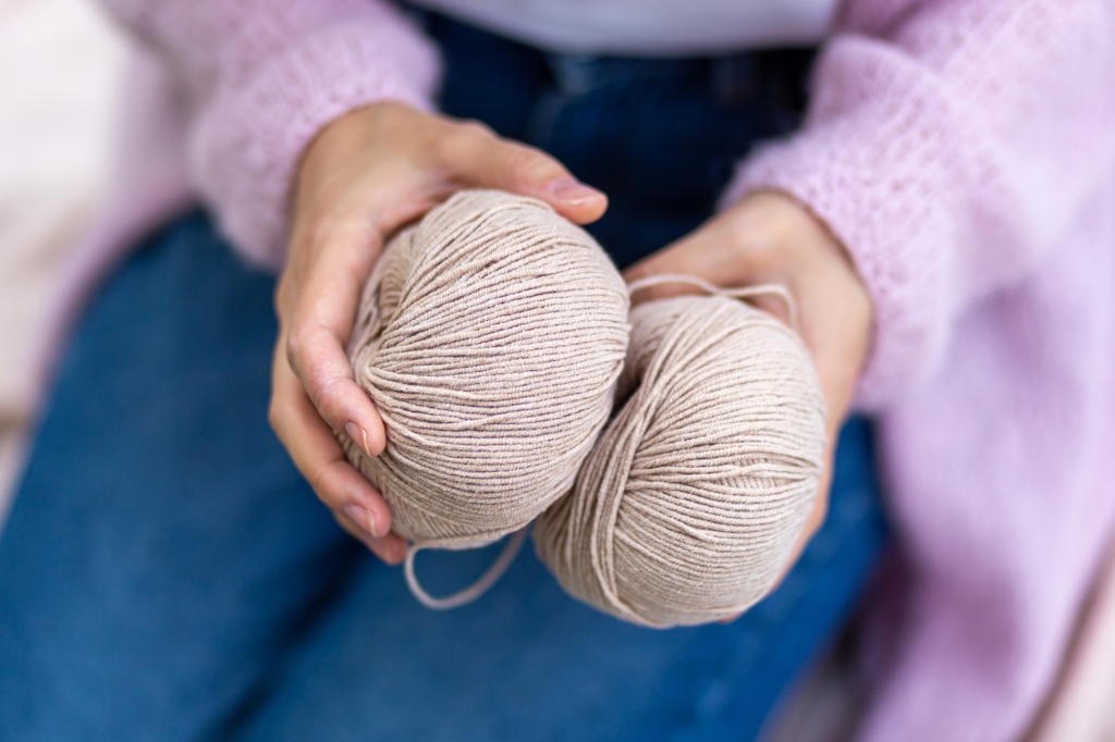 female hands holding balls of yarn