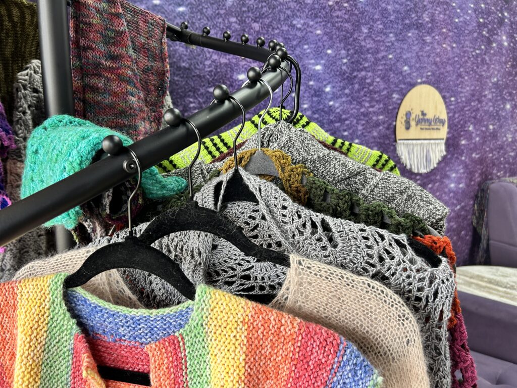 A variety of handknit and crocheted items in a yarn shop