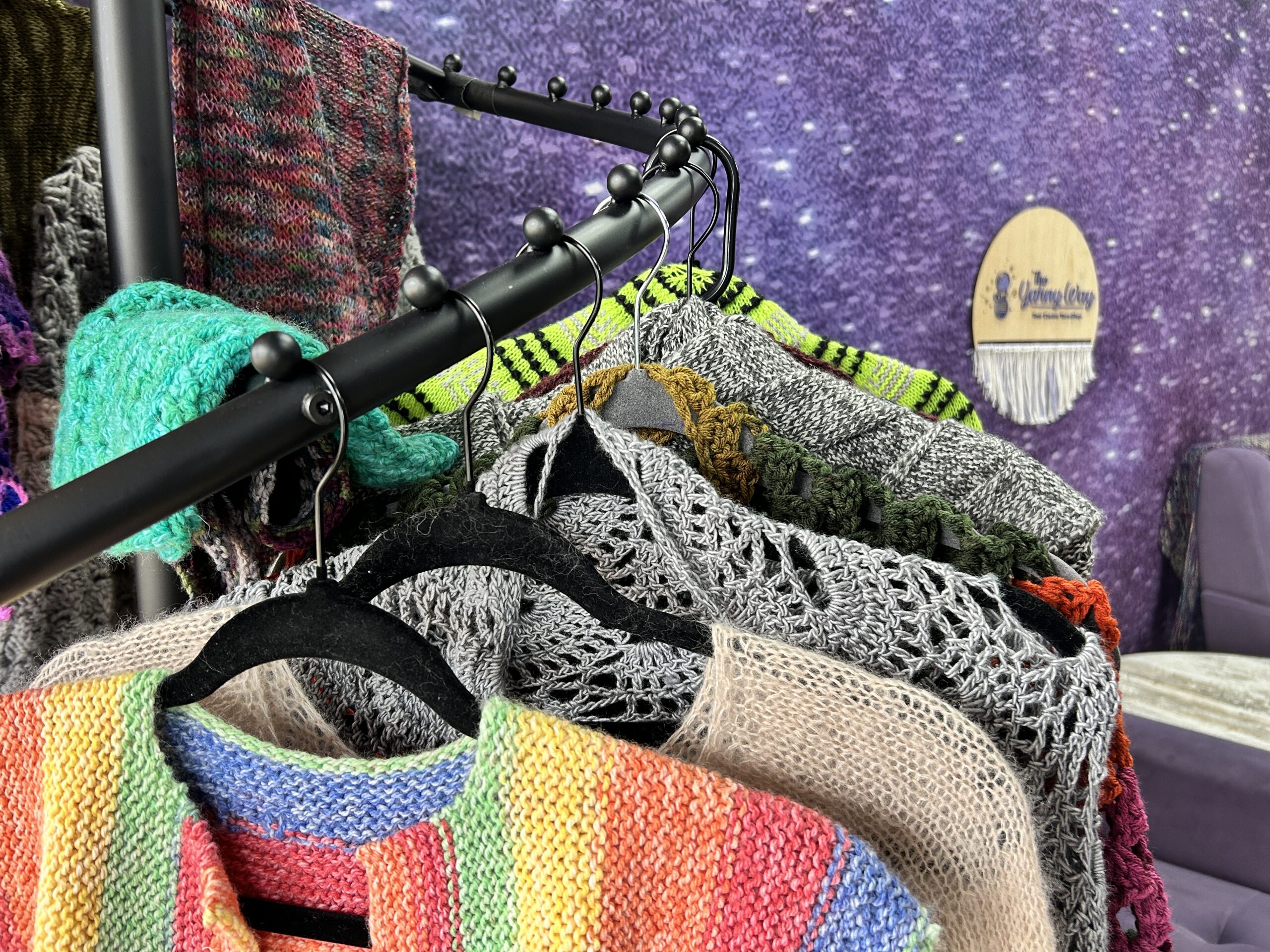 A variety of handknit and crocheted items in a yarn shop